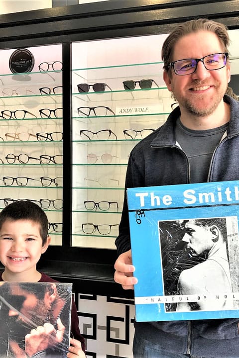 Milton artist and his son holding vinyl records of The Smiths Hat full of Hollow and Wham