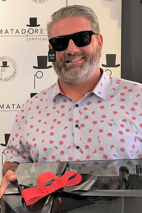 Dean Defazio wearing sunglasses made from vinyl records and holding the turntable he won in the raffle draw for Community Living North Halton
